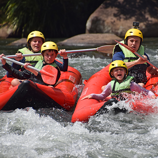 A family taking on the rapids on the Tully river